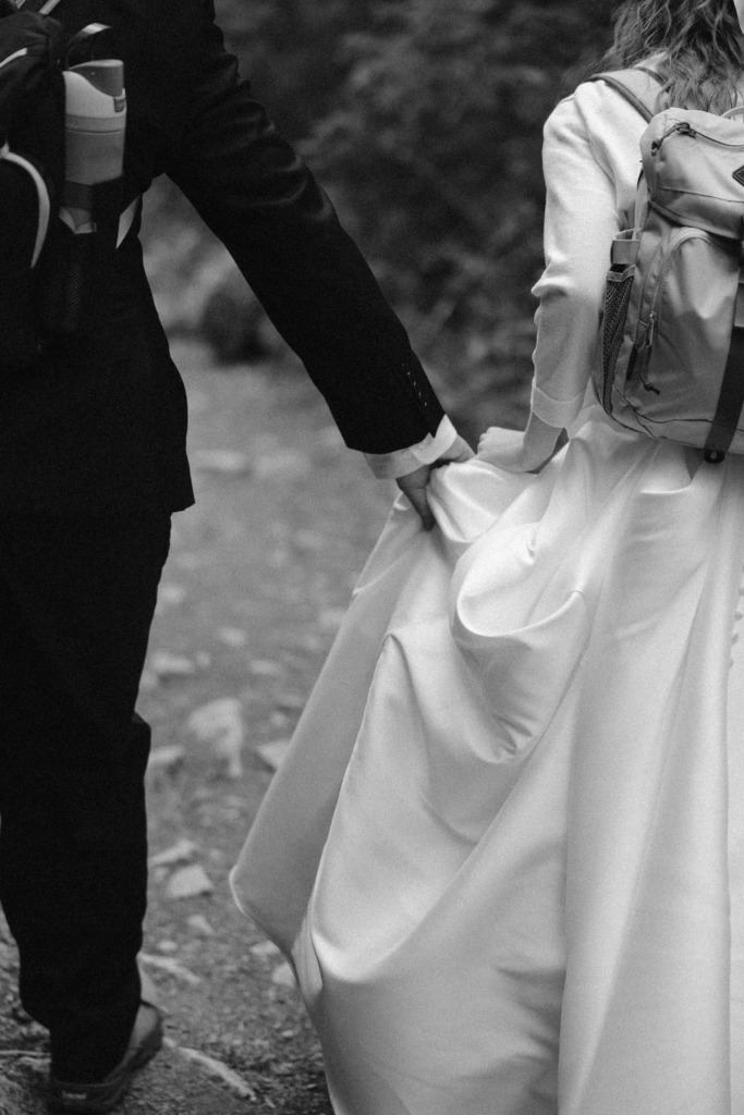 a couple wearing wedding attire and walking hand in hand