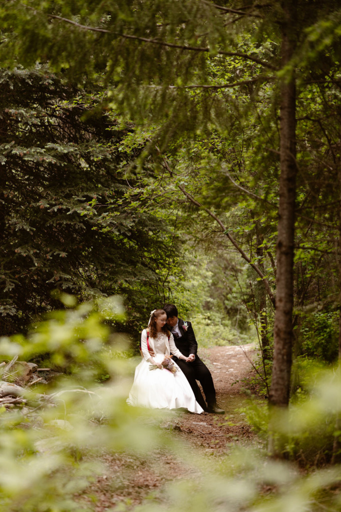 a couple wearing wedding attire in the woods