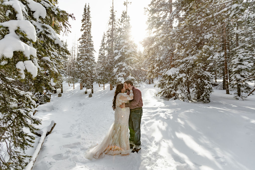 a couple standing in an evergreen forest during their bear lake wedding