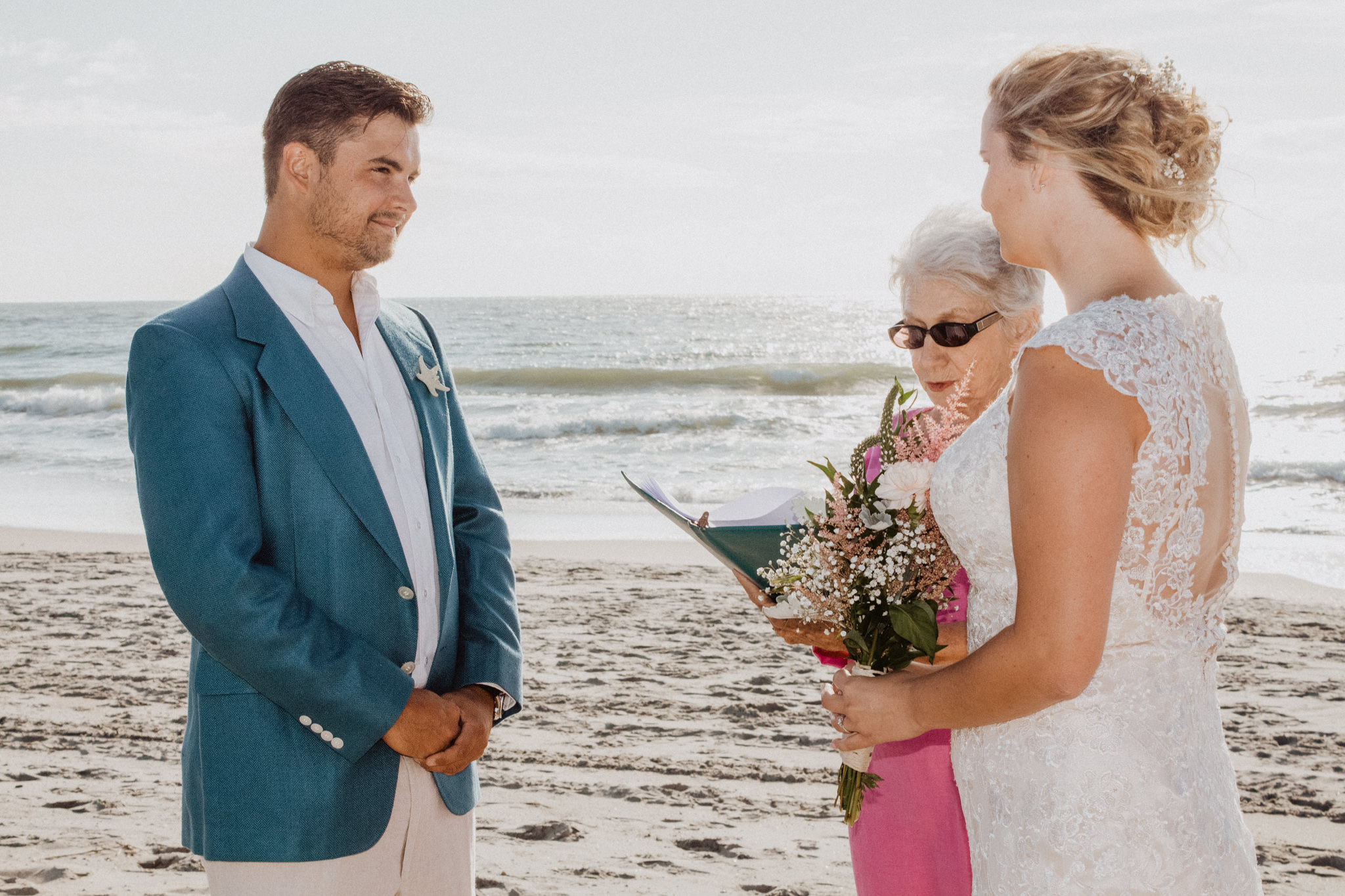 a beach elopement ceremony during sunrise on the beach next to the waves