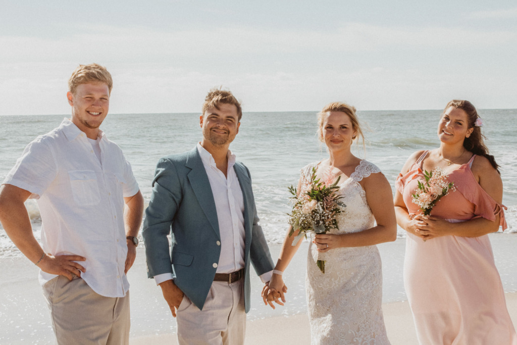 a bridal party standing in the sand for a beach elopement