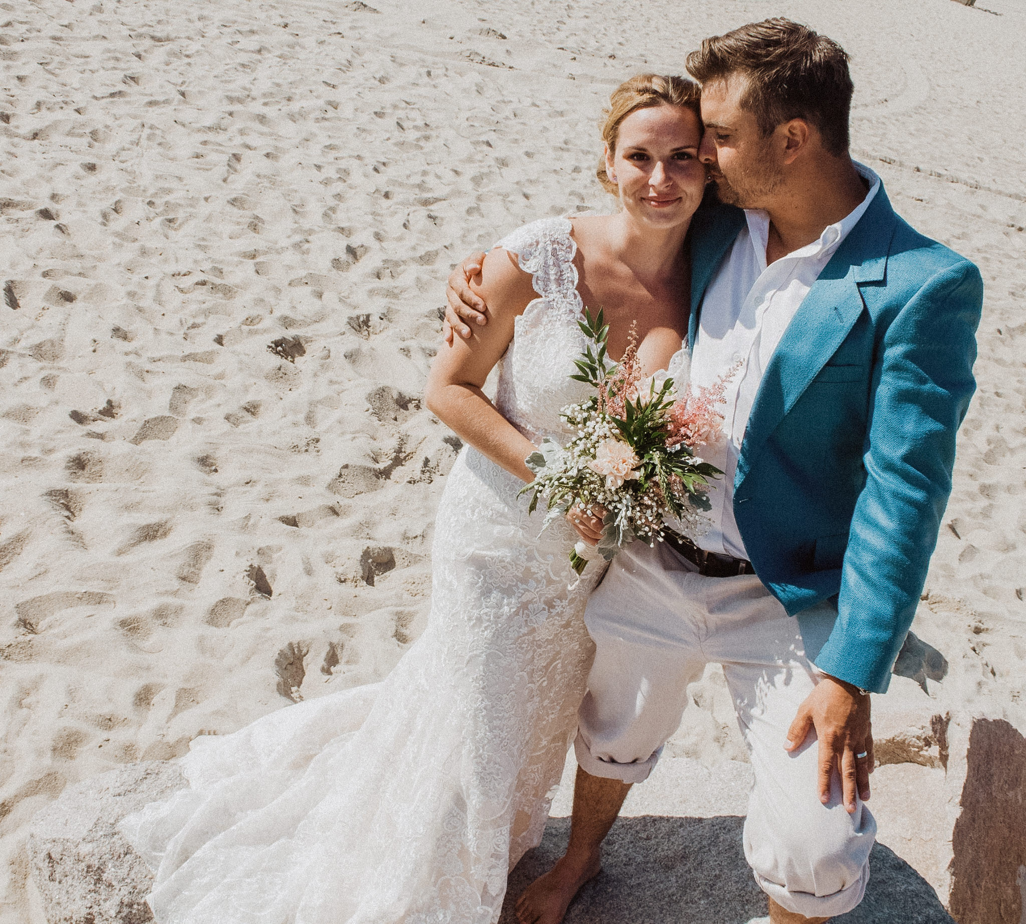 a bride and groom posing in the sand during their elopement