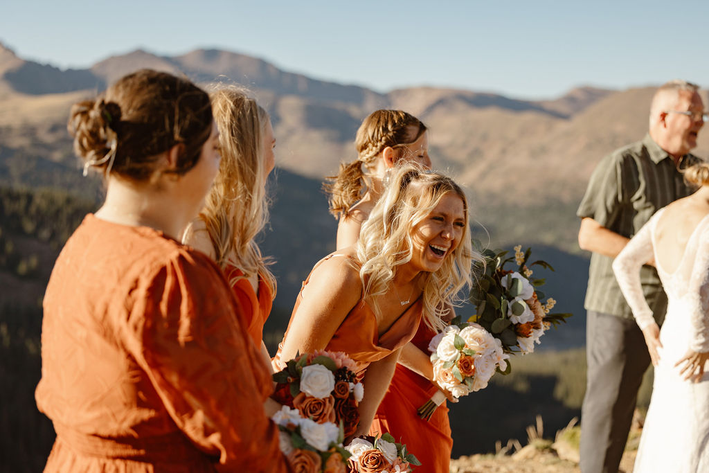 a group of bridesmaids laughing during a loveland pass elopement ceremony