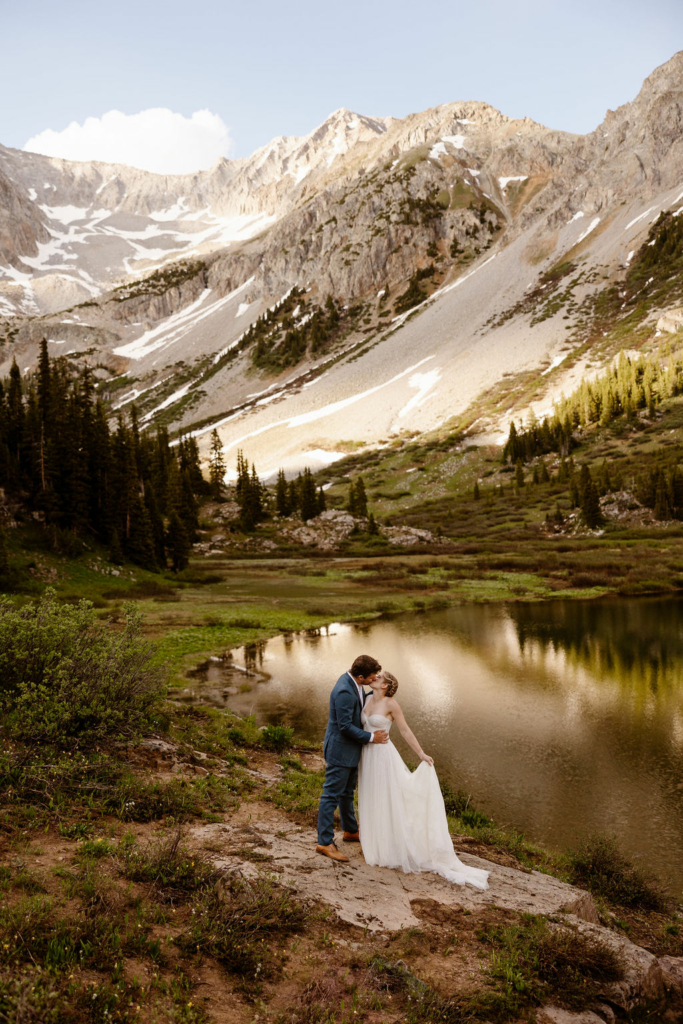 a couple wearing traditional wedding clothes holding their private ceremony in the mountains during their aspen elopement