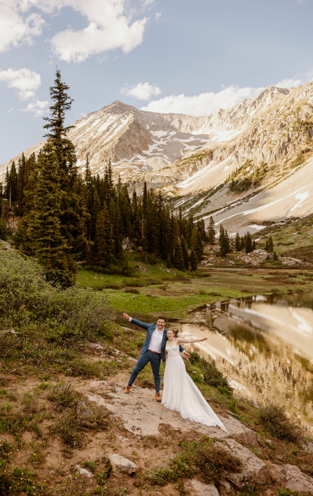 a couple wearing traditional wedding clothes holding their private ceremony in the mountains during their aspen elopement