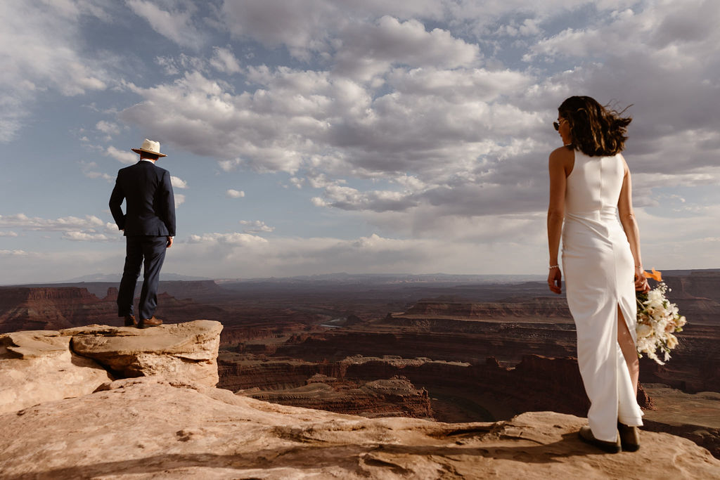 a bride and groom standing at the edge of a cliff in the canyonlands national park during their canyonlands wedding