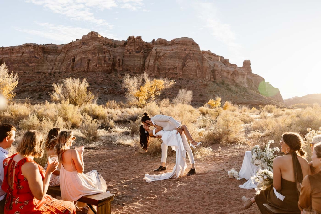 a couple kissing at their wedding ceremony at the red earth venue in moab