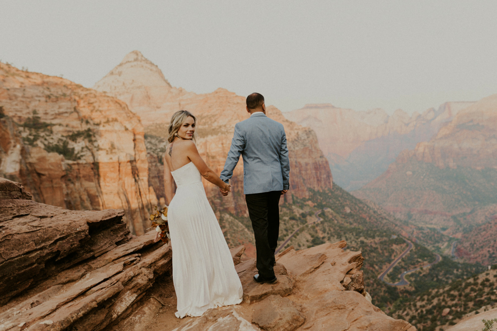 a couple wearing wedding attire getting married at zion national park